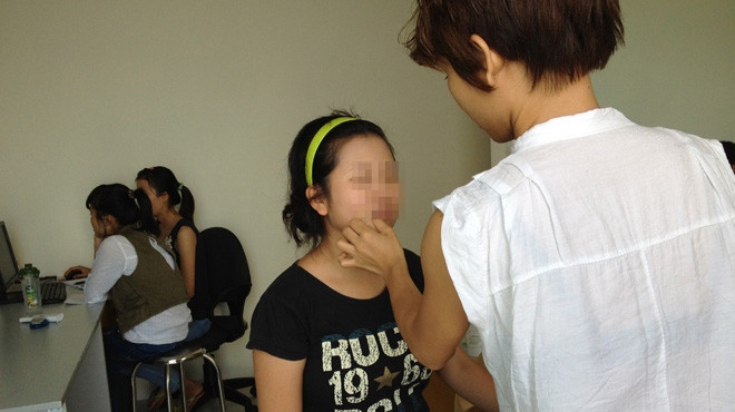 Trang điểm kỹ càng chuẩn bị chụp hình ở một công ty môi giới hôn nhân qua mạng. Ảnh: T. L.