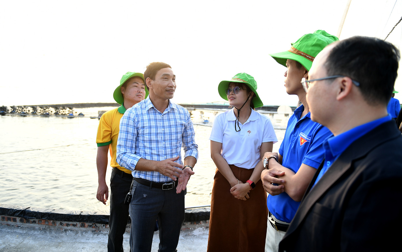 Anh Nguyễn Xuân Sứ chia sẻ hệ thống ao nuôi thuỷ sản tại hợp tác xã thanh niên Tiến Đạt. Ảnh: Dương Triều