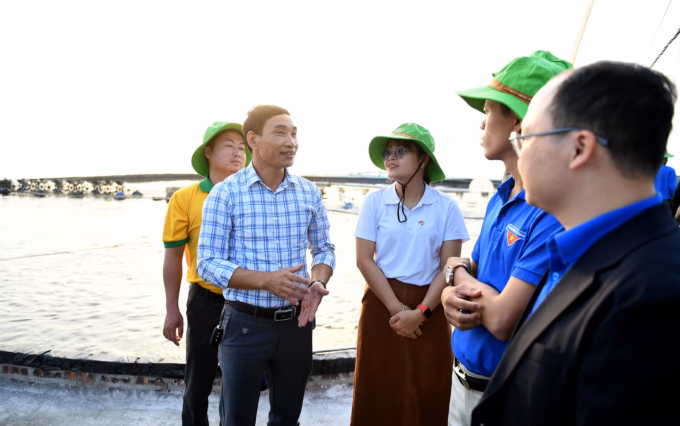 Anh Nguyễn Xuân Sứ chia sẻ hệ thống ao nuôi thuỷ sản tại hợp tác xã thanh niên Tiến Đạt. Ảnh: Dương Triều