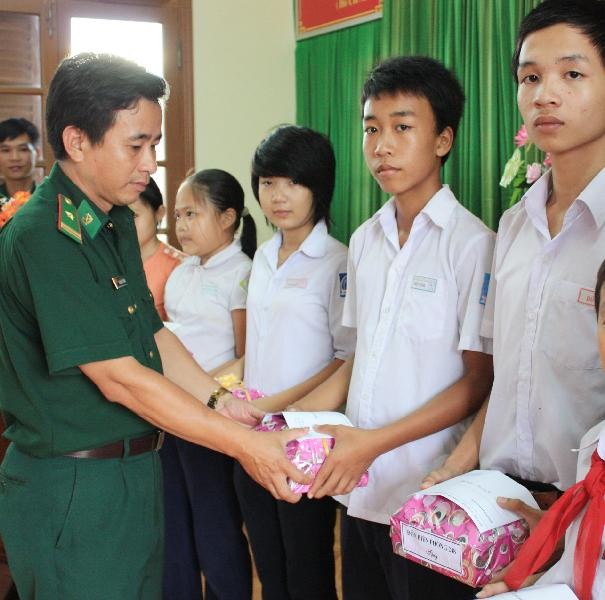 Thiếu tá Thanh tặng quà cho con em ngư dân. Ảnh: Nam Cường. Thiếu tá Thanh tặng quà cho con em ngư dân Ảnh: Nam Cường