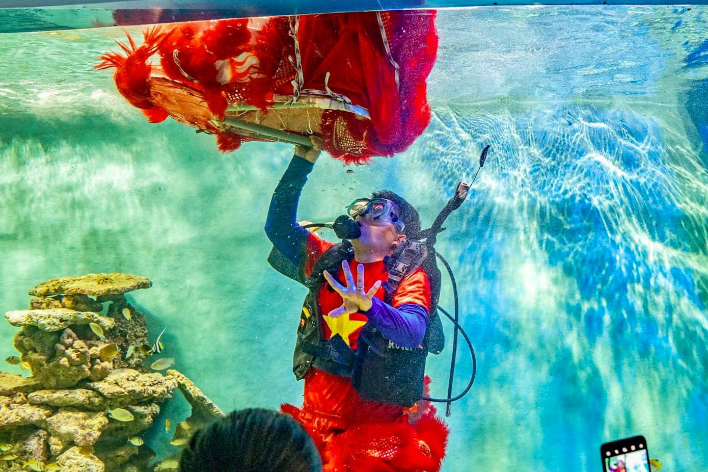 Nghệ sĩ múa lân là nhân viên của Viện Hải dương học, họ mang bình dưỡng khí khi thực hiện biểu diễn. (Ảnh: Khánh Nguyên).