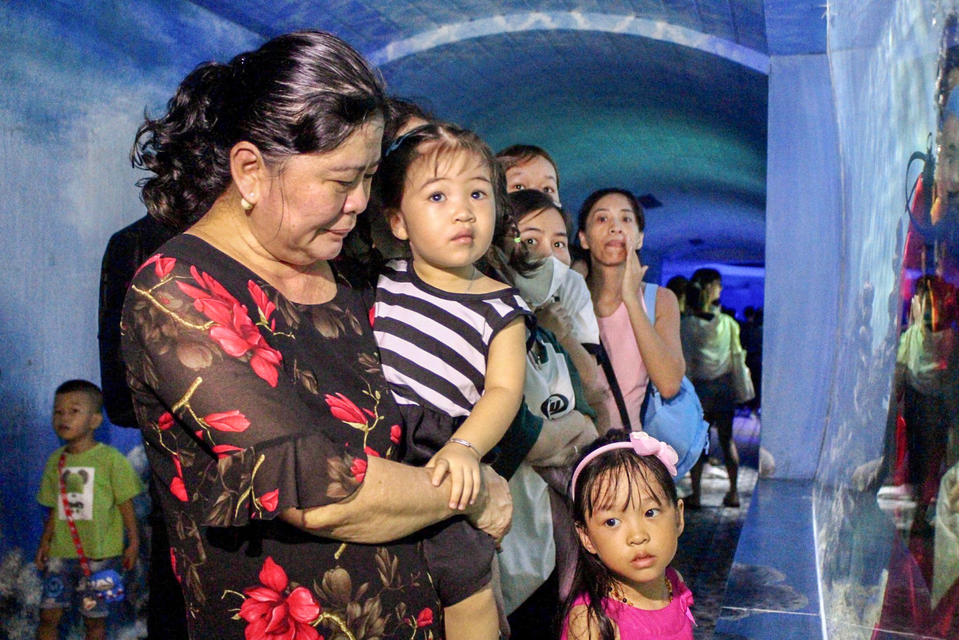 Bà Phạm Thanh Mai đưa cháu đến xem múa lân dưới nước. (Ảnh: Khánh Nguyên).