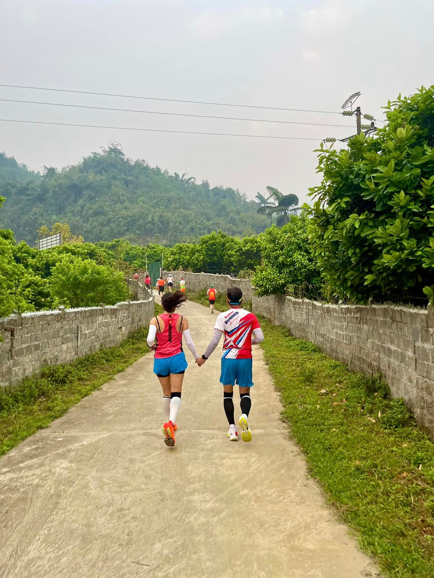 Nhà báo Đình Thắng và bà xã Nguyễn Ngọc Tú - song hành chinh phục cự ly 42km. Gia đình nhà báo Đình Thắng còn góp thêm hai VĐV nhỏ tuổi. Hai cậu con trai của anh chị chạy 10km. Anh Thắng còn huy động thêm người thân góp mặt trong Tiền Phong Marathon. Ảnh: NVCC.