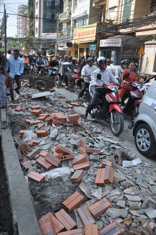 Đống vật liệu vương vãi xuống lòng đường khiến giao thông khu vực bị ùn tắc