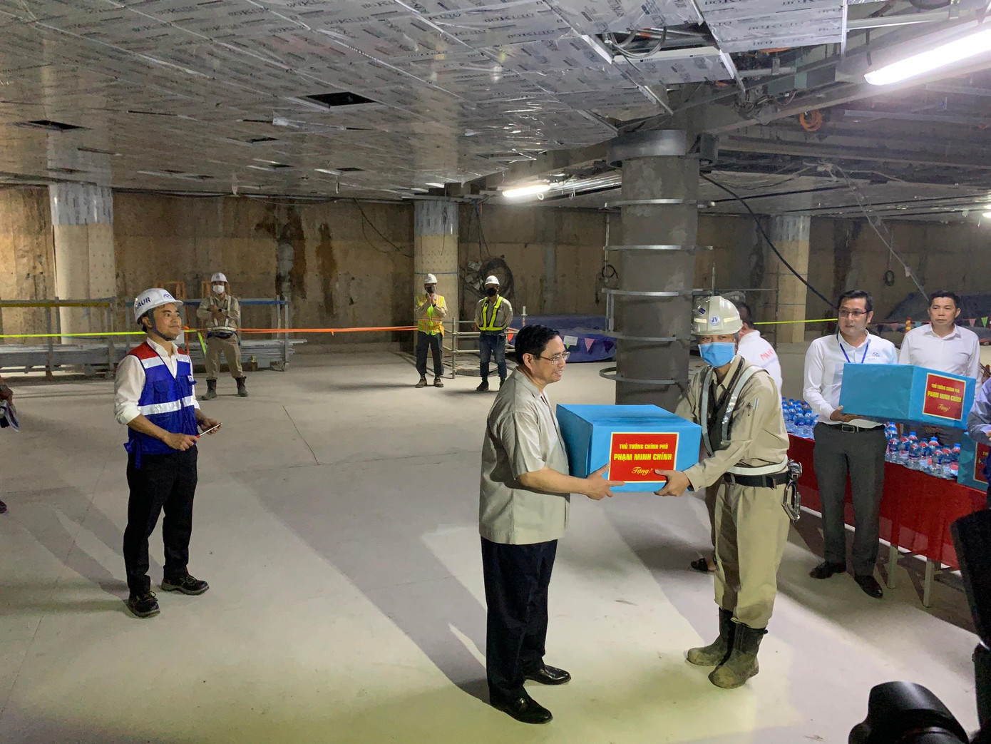Thủ tướng Chính phủ Phạm Minh Chính ân cần thăm hỏi và tặng quà cho đại diện quản lý, thi công công trình xây dựng dự án tuyến đường sắt đô thị số 1 tại ga Ba Son. Ảnh: MAUR