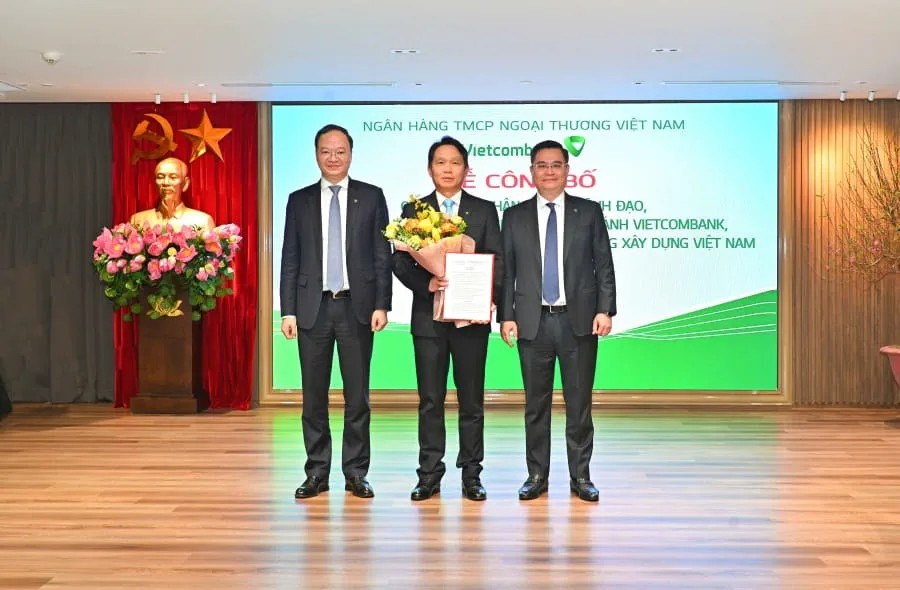 Ông Nguyễn Thanh Tùng - Chủ tịch HĐQT Vietcombank (bên phải) và ông Lê Quang Vinh - Phó Tổng Giám đốc Vietcombank (bên trái) trao quyết định và tặng hoa cho ông Nguyễn Mạnh Hùng - tân Chủ tịch HĐTV (kiêm nhiệm) CB.