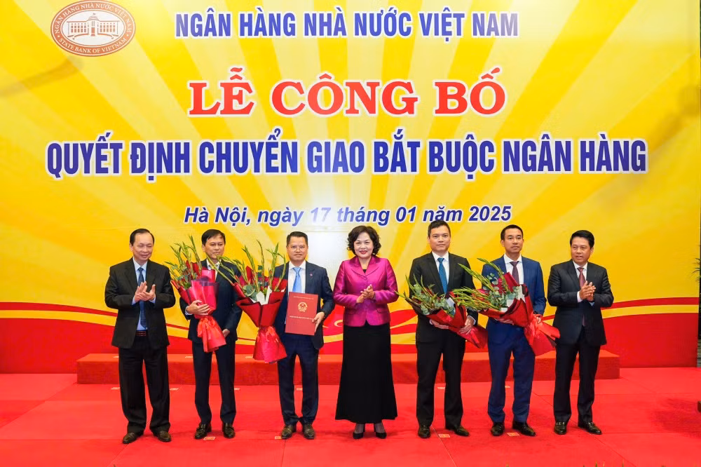 Thống đốc Ngân hàng Nhà nước trao quyết định chuyển giao 2 ngân hàng yếu kém (ảnh: SBV).