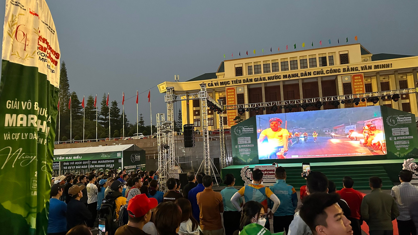 Người dân và cổ động viên theo dõi trực tiếp Tiền Phong Marathon 2023 qua màn hình trung tâm ở Quảng trường Nhân dân.