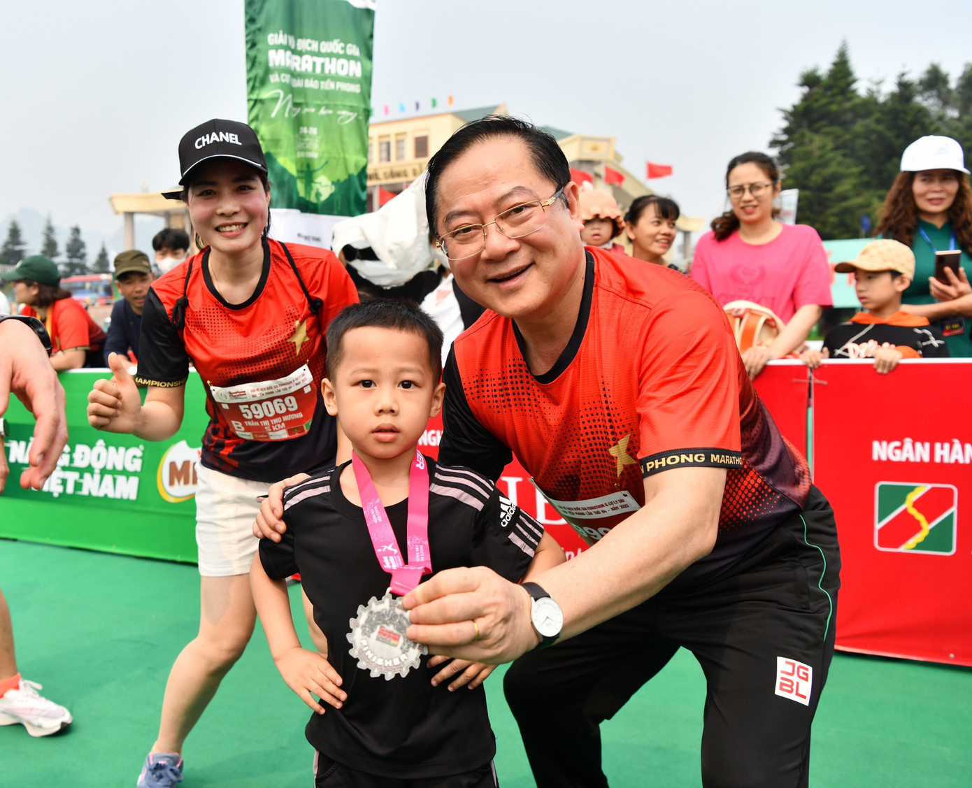 Nhà báo Lê Xuân Sơn - Tổng Biên tập báo Tiền Phong, đồng Trưởng Ban tổ chức Tiền Phong Marathon, chung vui cùng vận động viên nhí tại vạch đích.
