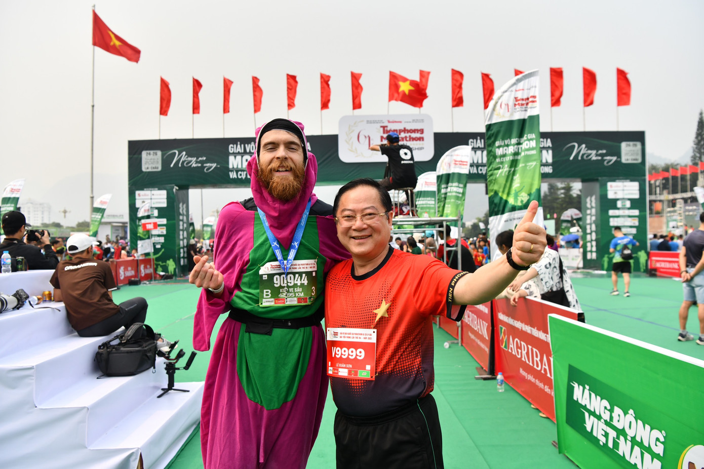 Nhà báo Lê Xuân Sơn - Tổng Biên tập báo Tiền Phong, đồng Trưởng Ban tổ chức Tiền Phong Marathon, chung vui cùng vận động viên người nước ngoài tại vạch đích.