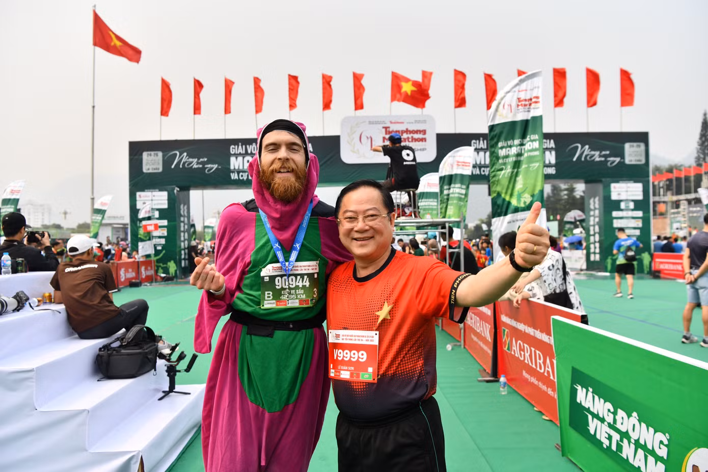 Nhà báo Lê Xuân Sơn - Tổng Biên tập báo Tiền Phong, đồng Trưởng Ban tổ chức Tiền Phong Marathon, chung vui cùng vận động viên người nước ngoài tại vạch đích.