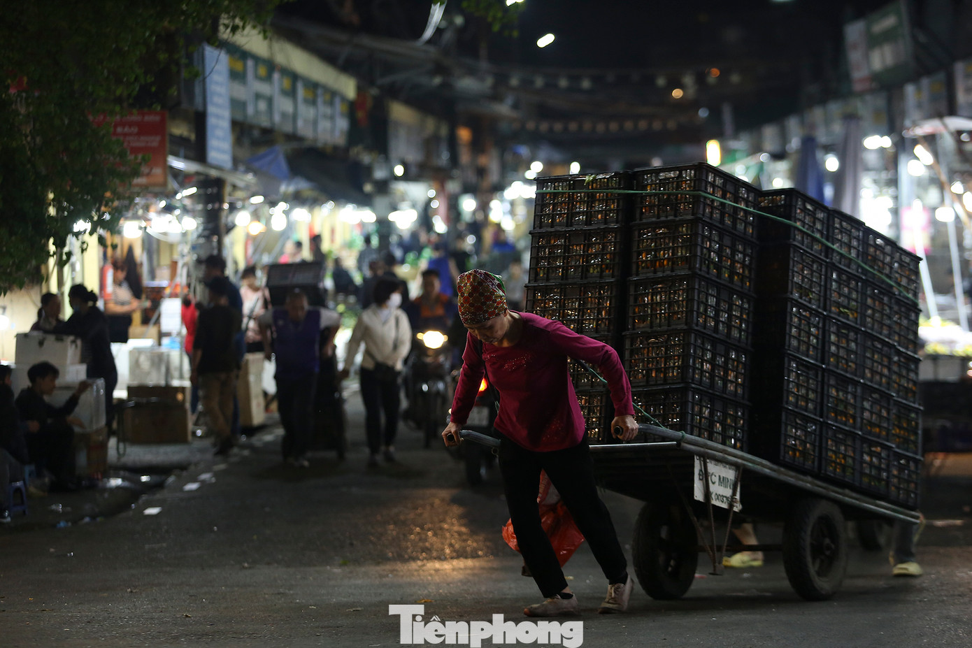 Một nữ cửu vạn gồng mình kéo xe hàng tại chợ Long Biên