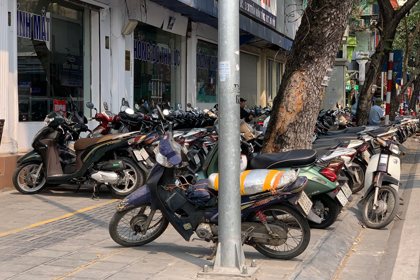 Tuy nhiên, tại một số nơi tình trạng lấn chiếm vỉa hè vẫn còn phổ biến. Vỉa hè rộng nhưng chật cứng bởi bãi xe máy trên phố Trần Nhân Tông (quận Hai Bà Trưng).