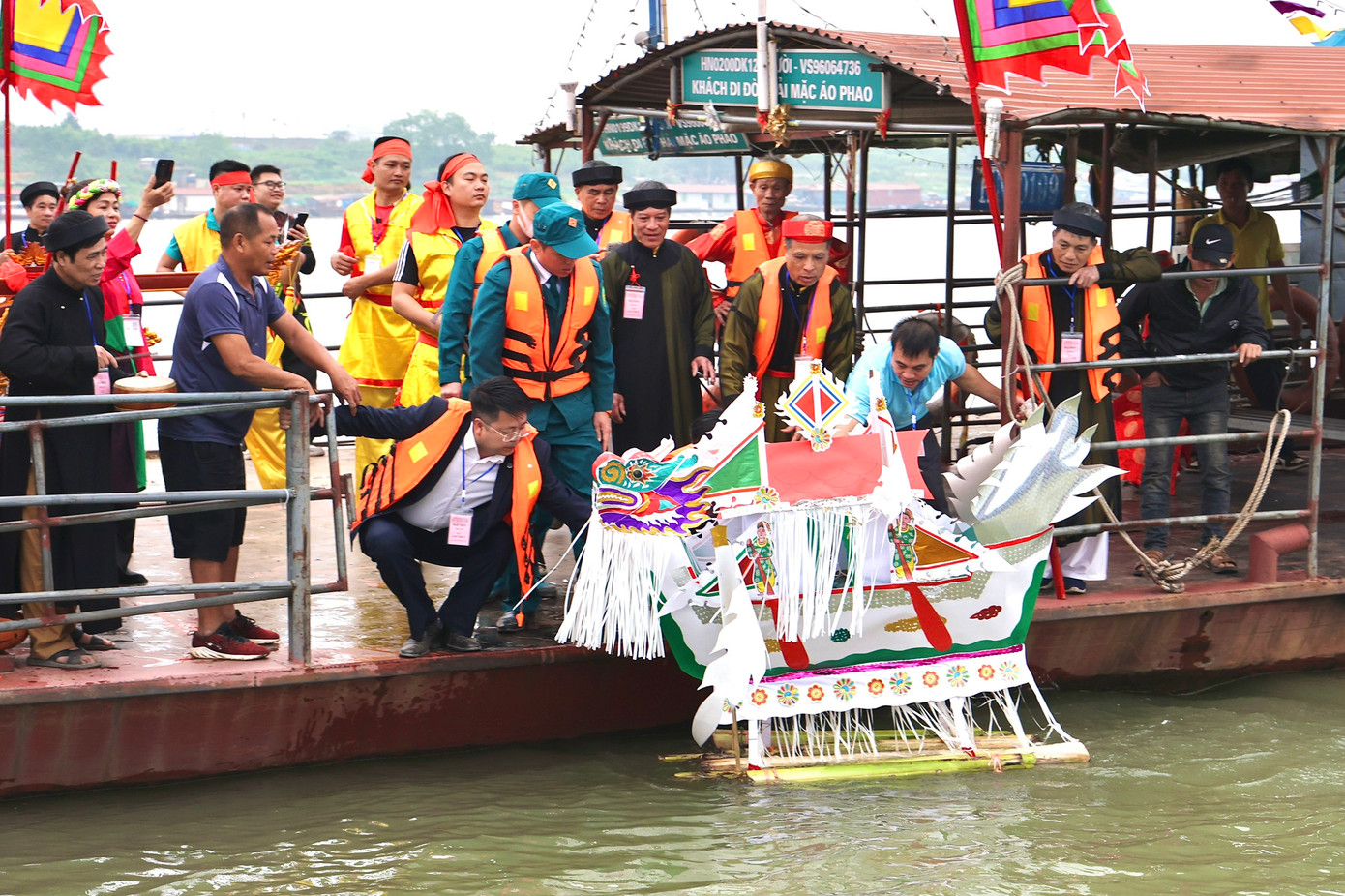 Thuyền giấy được thả trôi giữa dòng sông Hồng.