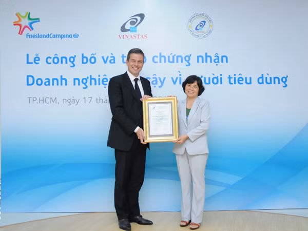 Bà Lê Thị Cẩm Nhung – Phó chủ tịch VINASTAS trao chứng nhận “Doanh nghiệp Tin cậy vì Người tiêu dùng” cho ông Mark Boot - Tổng Giám đốc Công ty FrieslandCampina Việt Nam
