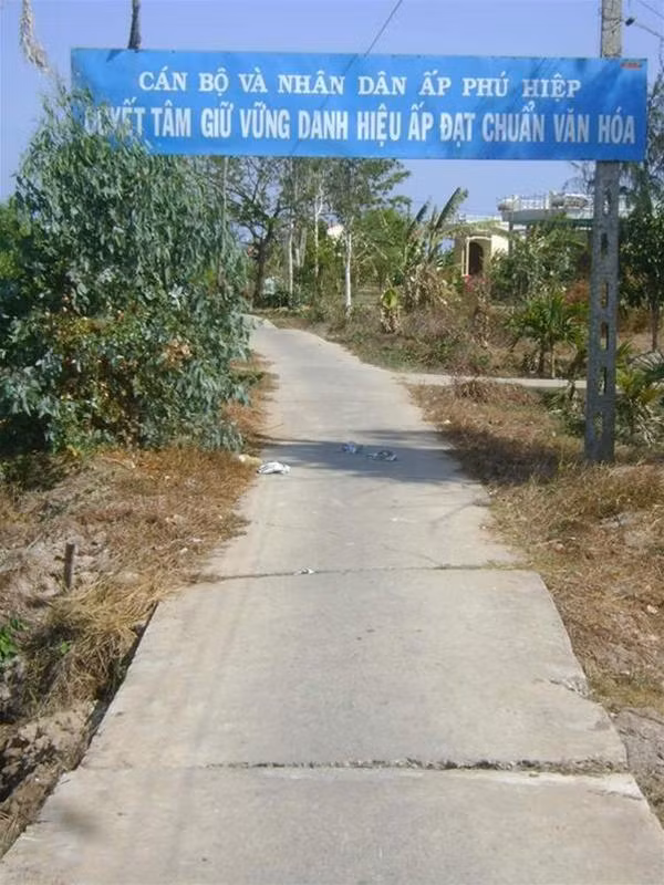 Khẩu hiệu lớn "Quyết tâm giữ vững danh hiệu ấp đạt chuẩn văn hóa" được treo ngay trên đường vào ấp, nơi xảy ra vụ hành hạ man rợ trẻ em. Ảnh : Tiến Hưng