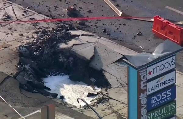 Một cái hố lớn trên mặt đất sau vụ rơi máy bay. Ảnh: WPVI via Reuters.