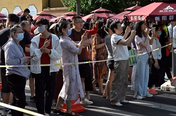 Phụ huynh chụp ảnh các con đi thi. Ảnh: Adek Berry/ AFP/ Getty.