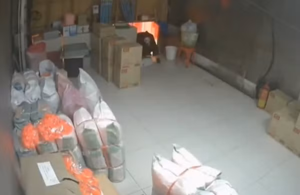 "Mặt ma" chán nản ngồi một góc trong tiệm vàng, chờ trời sáng. Ảnh: SCMP.