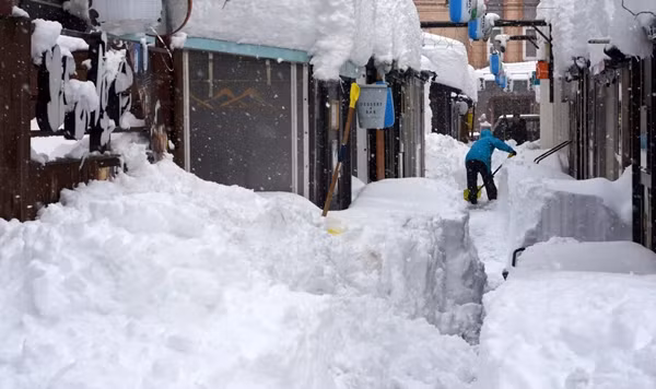 Một người đang đào tuyết ở Obihiro (Hokkaido, Nhật Bản). Ảnh: Jiji Press/ EPA.