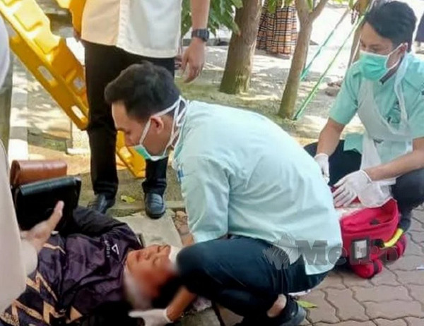 Cô Yazid được trợ giúp sau khi bị xe đạp rơi trúng đầu". Ảnh: Baharom Bakar.