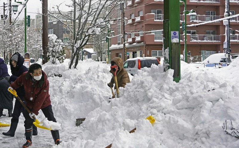 Người dân đang xúc tuyết ở Hokkaido. Ảnh: AP.