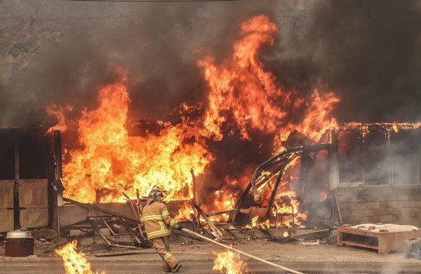 Một người lính cứu hỏa đang cố dập một ngọn lửa ở Uiseong (Hàn Quốc). Ảnh chụp ngày 25/3. Ảnh: Yoon Gwan-shik/ Yonhap via AP.