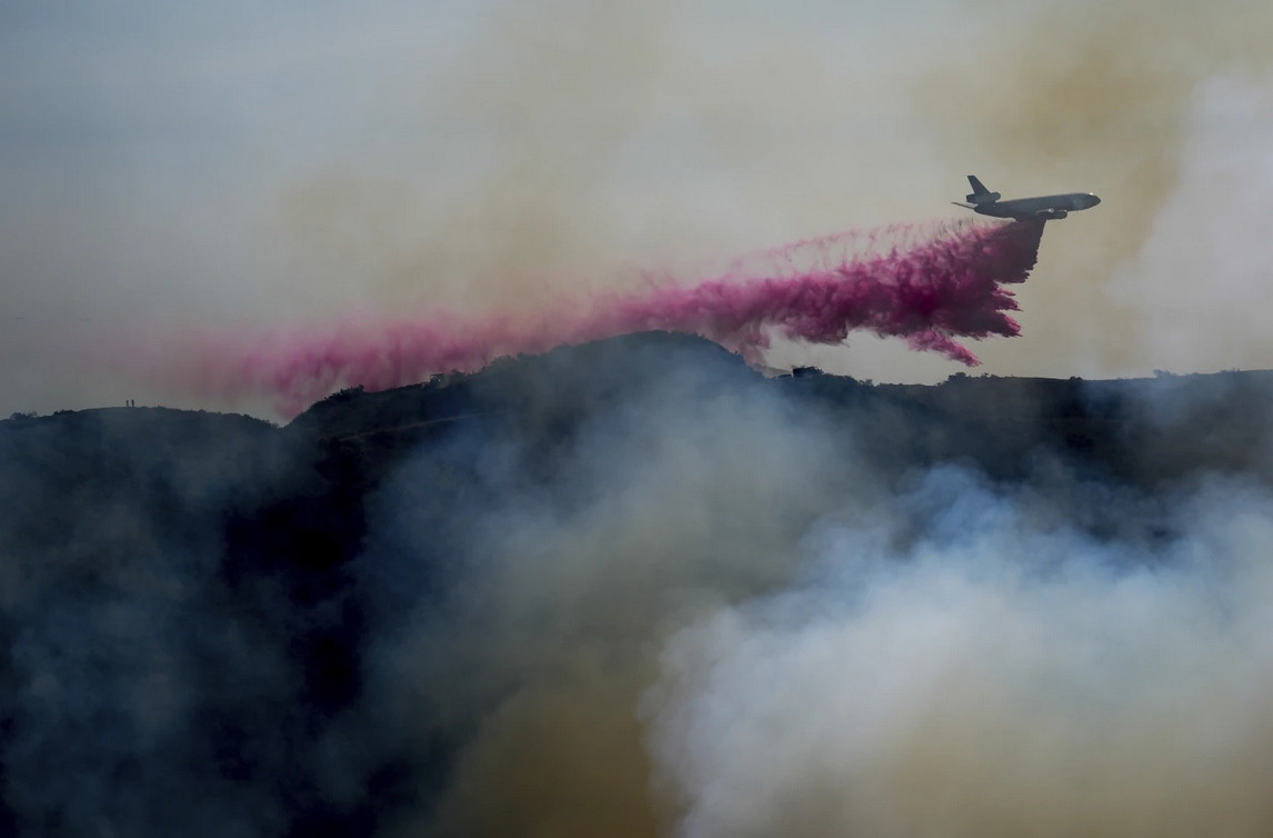 Máy bay thả chất chống cháy màu hồng xuống Los Angeles. Ảnh: Eric Thayer/ AP. Máy bay thả chất chống cháy màu hồng xuống Los Angeles. Ảnh: Eric Thayer/ AP.