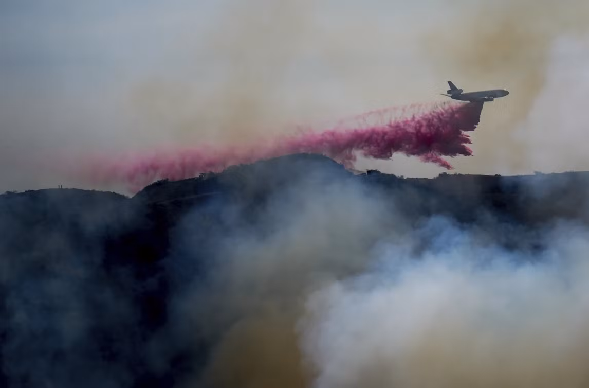 Máy bay thả chất chống cháy màu hồng xuống Los Angeles. Ảnh: Eric Thayer/ AP. Máy bay thả chất chống cháy màu hồng xuống Los Angeles. Ảnh: Eric Thayer/ AP.