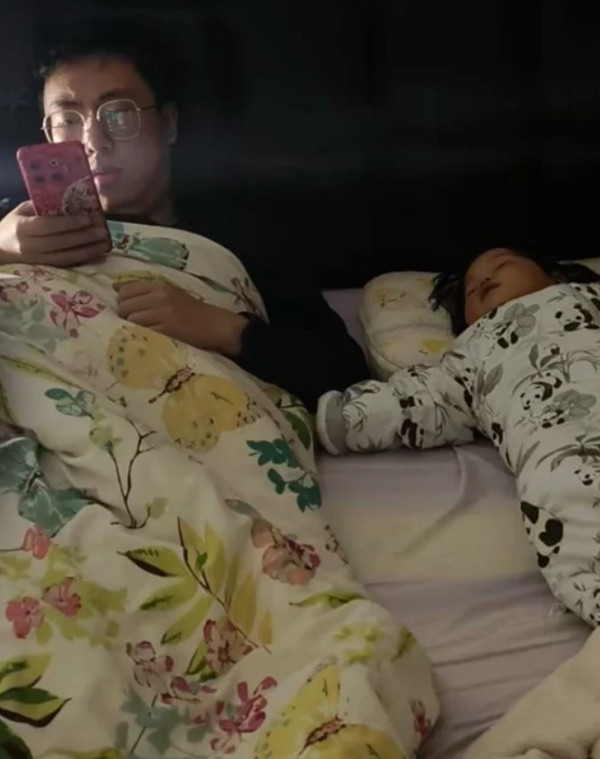 Người cha tranh thủ bán hàng online trong khi con ngủ. Ảnh: Baidu. Người cha tranh thủ bán hàng online trong khi con ngủ. Ảnh: Baidu.