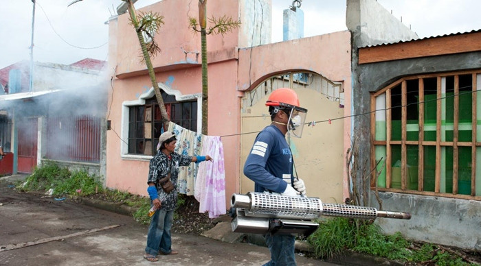 Một người dùng máy phun thuốc diệt muỗi ở thành phố Tacloban (Philippines). Ảnh: Eleanor Farmer/ Oxfam.