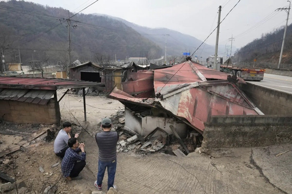 Người dân buồn bã nhìn những ngôi nhà cháy rụi của mình ở Cheongsong (Hàn Quốc). Ảnh chụp ngày 27/3. Ảnh: Ahn Young-joon/ AP.