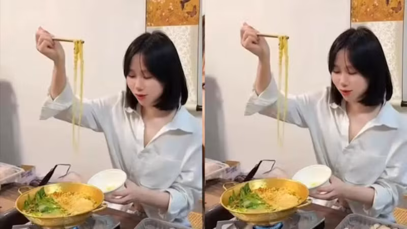 Cô gái ăn lẩu trong chiếc nồi bằng vàng. Ảnh: Jiupainews.