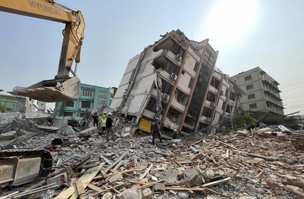 Các nhân viên cứu hộ đang làm nhiệm vụ ở các tòa nhà bị sập sau trận động đất tại Mandalay (Myanmar). Ảnh: Jiang Chao/ Xinhua via AP.