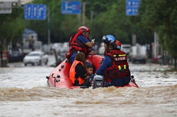 Nhân viên cứu hộ giúp người dân ở huyện Hoài Tập đi sơ tán. Ảnh: China Daily via Reuters. Nhân viên cứu hộ giúp người dân ở huyện Hoài Tập đi sơ tán. Ảnh: China Daily via Reuters.