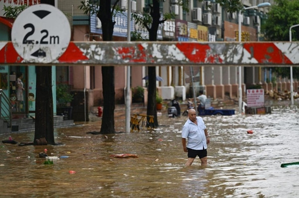 Một người dân ở tỉnh Quảng Đông lội trên phố ngập lụt hôm 17/6. Ảnh: AFP. Một người dân ở tỉnh Quảng Đông lội trên phố ngập lụt hôm 17/6. Ảnh: AFP.