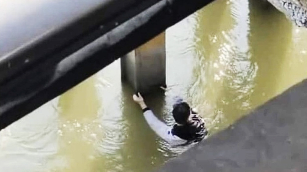 Hình ảnh nam thanh niên tự bơi vào phần trụ cầu Long Biên sau khi nhảy từ trên cầu xuống sông Hồng (Ảnh: Hoàng Tứ).