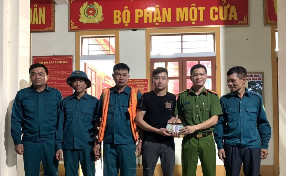 Lực lượng chức năng trao trả ví tiền cho người dân đánh mất. (Ảnh: Phan Giang)