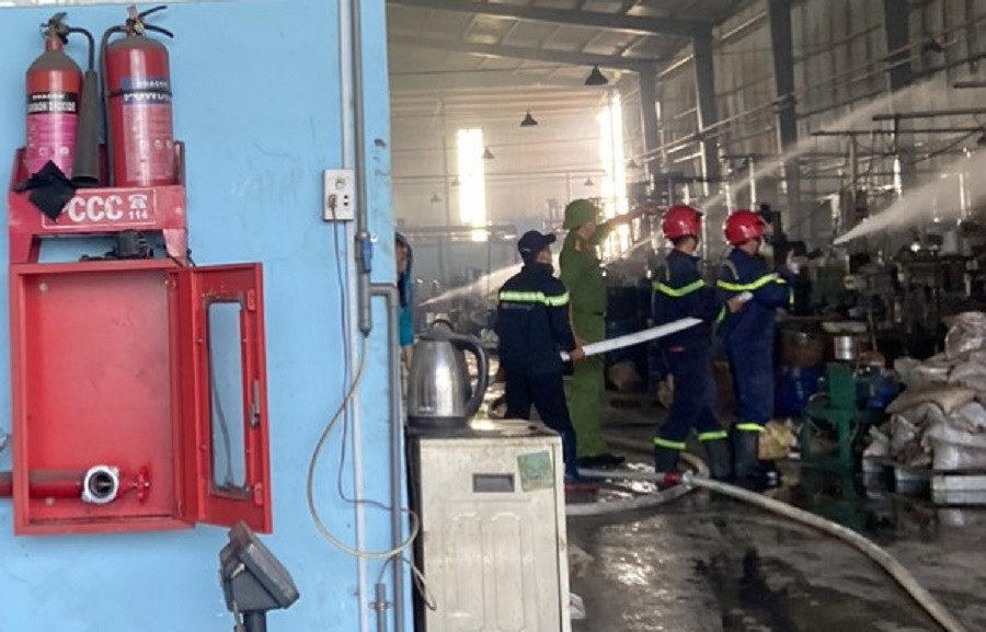 Lực lượng cảnh sát tiến sâu vào bên trong công ty sản xuất cơ khí để khống chế đám cháy. Ảnh: MĐ.