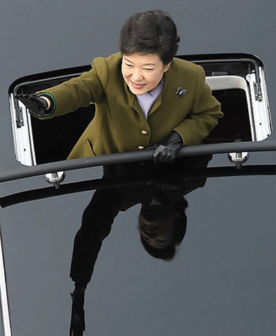 Tổng thống Hàn Quốc Park Geun-hye đứng trên chiếc limousine tươi cười vẫy tay chào người dân hôm 25/2