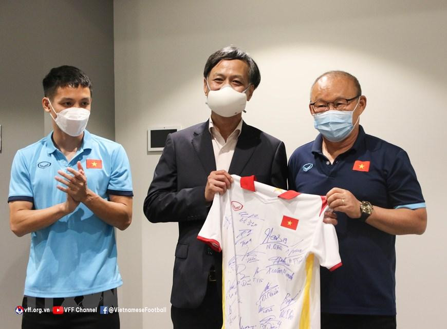 Đại sứ Nguyễn Tất Thành đã trao quà cho toàn thể đội bóng, trong khi đội tuyển cũng tặng Đại sứ một chiếc áo thi đấu có chữ ký của toàn thể đội. (Nguồn: TTXVN phát)