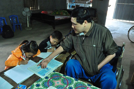 Anh hướng dẫn các học sinh làm bài, viết chữ rất tận tình và sát sao. Khi giảng bài, anh phải ngồi trên xe lăn, viết bằng miệng