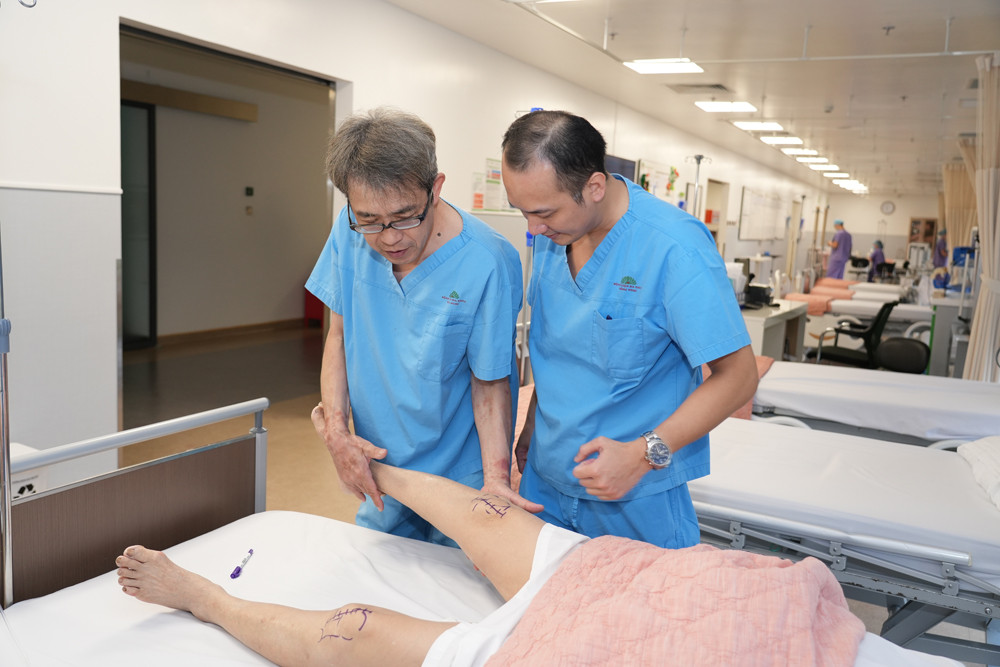 GS. Hiranaka Takafumi (bên trái) cùng TS.BS Lê Quang Huy thăm khám bệnh nhân trước phẫu thuật.