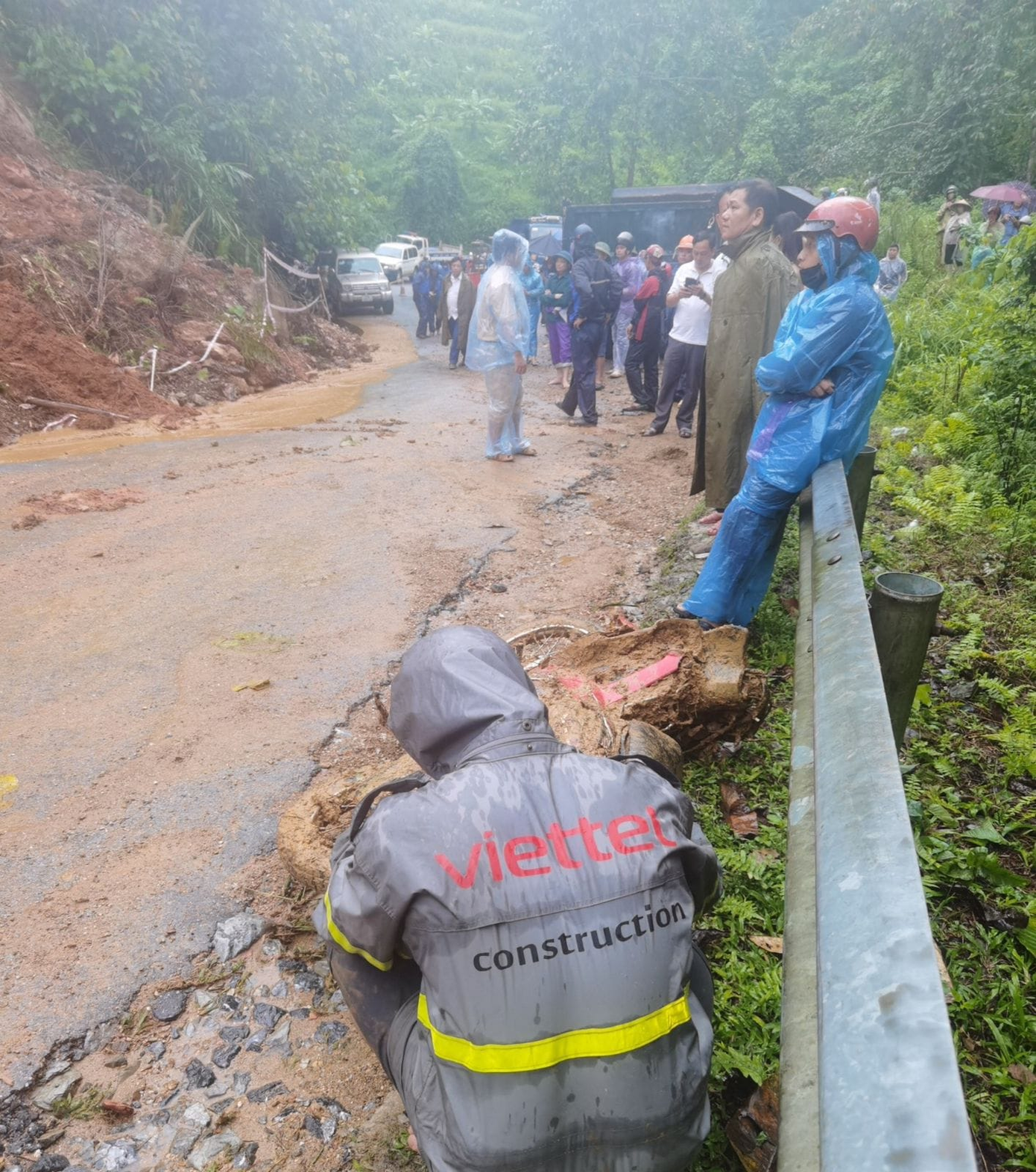 Anh Tài mệt mỏi ngồi gục xuống bên chiếc xe máy bị đất đá vùi lấp Anh Tài mệt mỏi ngồi gục xuống bên chiếc xe máy bị đất đá vùi lấp
