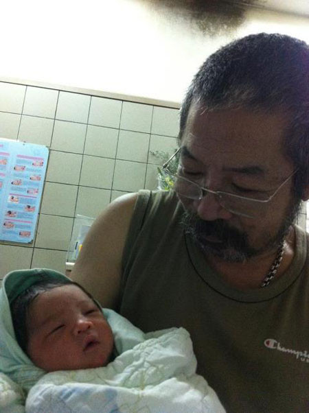 Lê Hùng bế con trai bé bỏng. Lê Hùng bế con trai bé bỏng