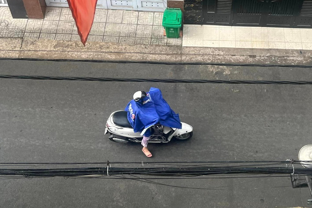 Một người dân mặc áo mưa đi làm buổi sáng nay tại quận Gò Vấp (Ảnh: H.T.)