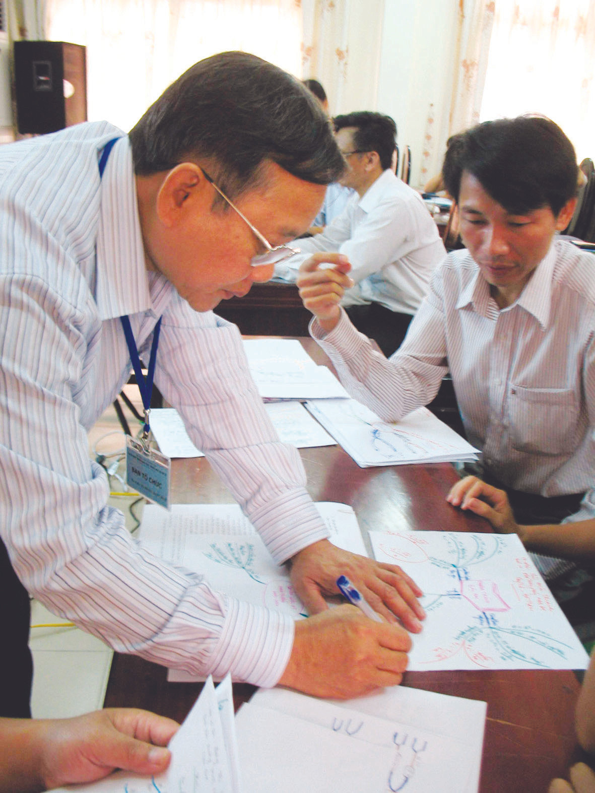 Chuyên gia của Bộ GD&ĐT đang chấm bài tập thiết kế bản đồ tư duy của giáo viên Ảnh: Q.H