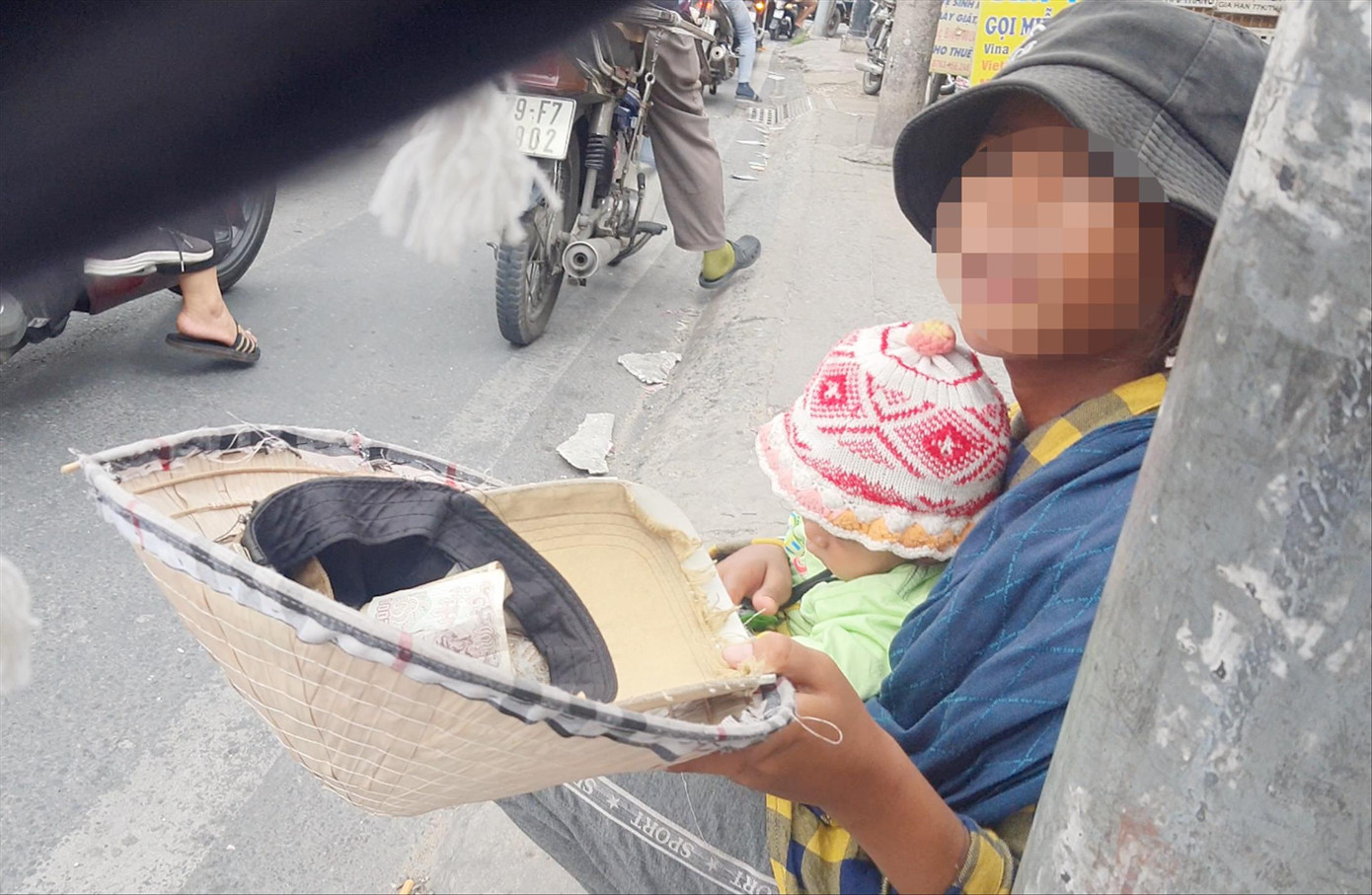 Bé gái 13 tuổi ẵm em ăn xin trên đường Hòa Bình. Ảnh: Thuận Nhàn Bé gái 13 tuổi ẵm em ăn xin trên đường Hòa Bình. Ảnh: Thuận Nhàn