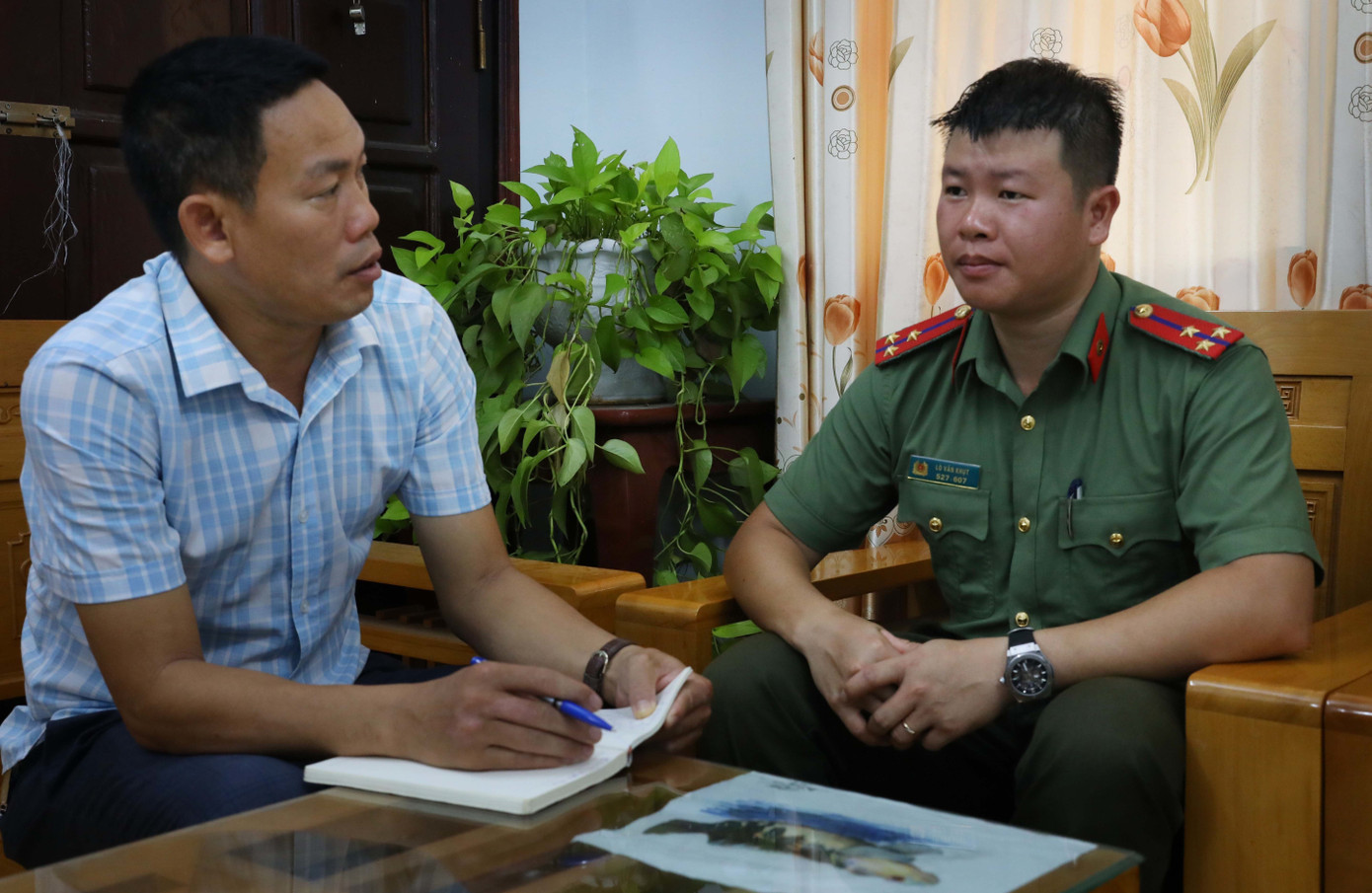 Thượng úy Lò Văn Khụt (phải) trao đổi với tác giả. Ảnh: TTXVN