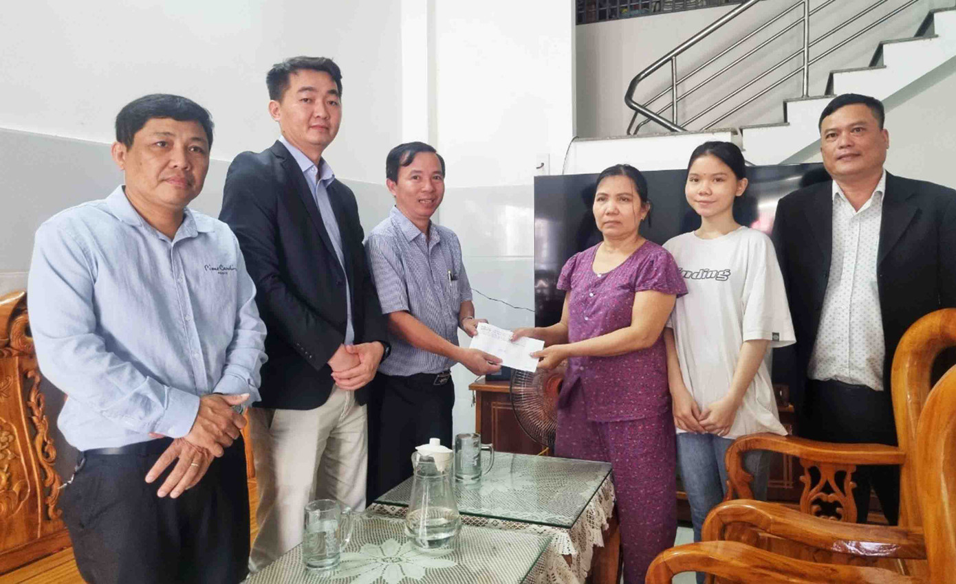 Thầy Nguyễn Hữu Phú - Phó Hiệu trưởng ĐH Duy Tân trao quyết định học bổng toàn phần cho em Mỹ Linh. ảnh: Thanh Trần